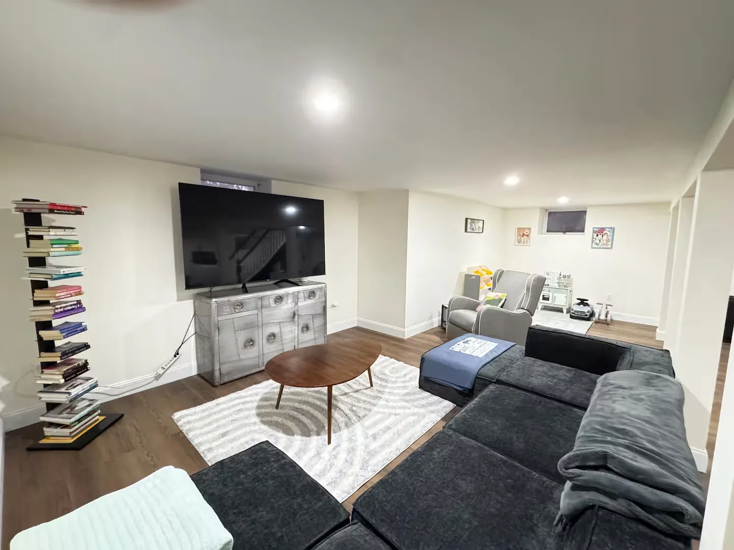Finished basement lounge with sectional and large TV